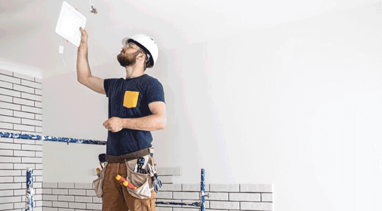 Um homem de capacete está segurando uma luminária