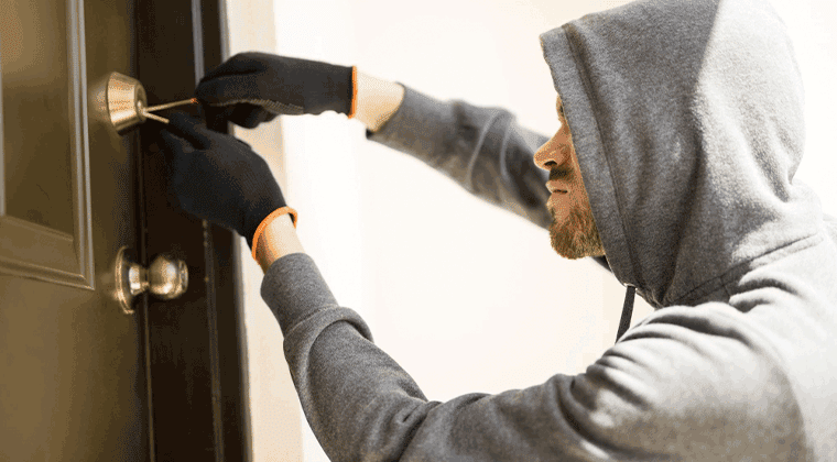 Um homem com capuz está abrindo uma porta