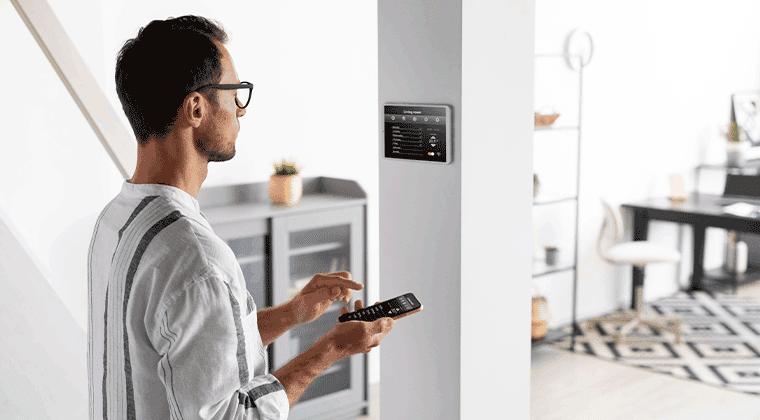 Homem segurando um controle configurando um painel de segurança