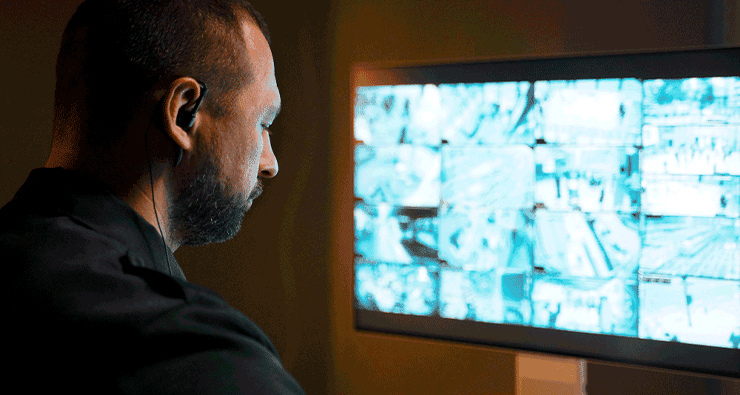 Um homem sentado em frente a um monitor de computador