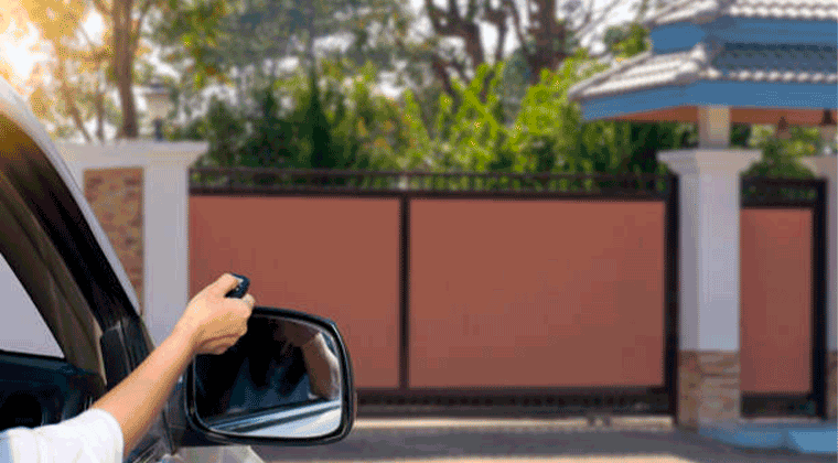 Mulher abrindo um portão elétrico apertando um controle